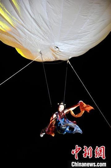 一名演员身穿“飞天服”，乘氦气球在空中翩翩起舞。　高龙安 摄