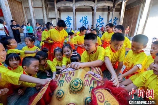 孩子们近距离感受英坑舞狮。　樊成柱 摄