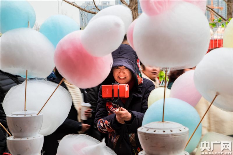 运河文化庙会中的游客在拍摄棉花糖.(央广网记者 张佳琪 摄)