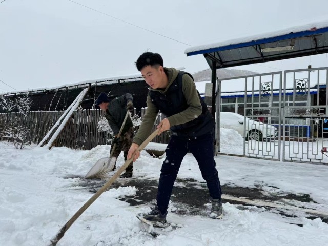 李建军父子俩在清扫家门口的积雪。人民网记者 曾帆摄