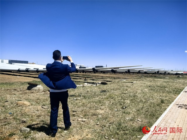 外媒记者拍摄厂房外的风力涡轮发电机的巨型浆叶。人民网 杨春燕摄