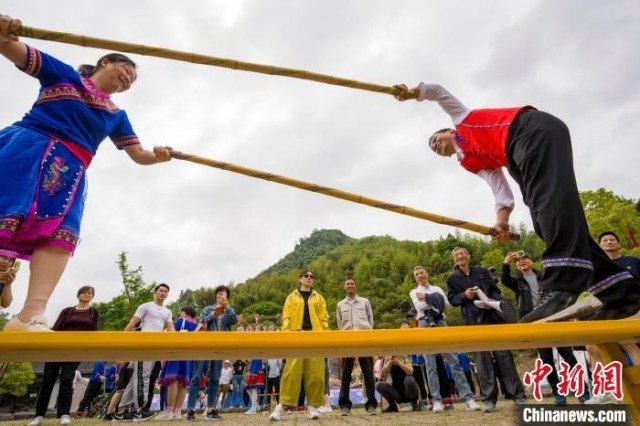 5月7日，宁国市云梯畲族风情园里的特色活动引来外地游客纷纷驻足观看，与村民们互动。　李晓红 摄