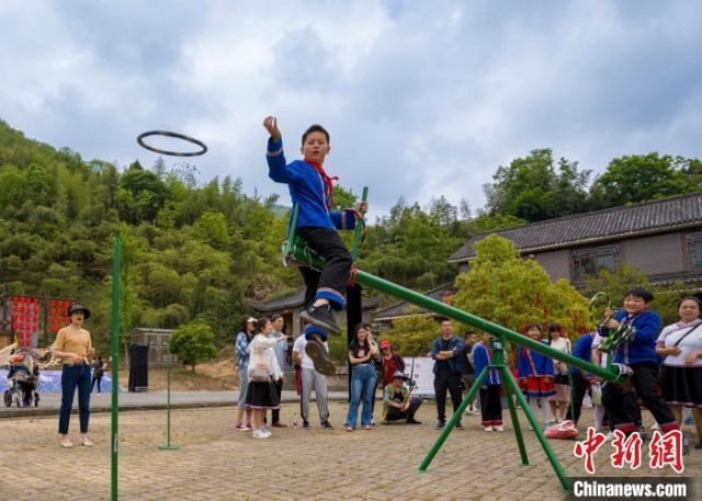 宁国市云梯畲族风情园里的特色活动引来外地游客纷纷驻足观看，与村民们互动。　李晓红 摄